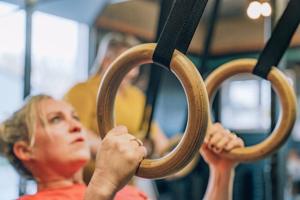 What to Expect from Gyms Near You: CrossFit vs Traditional Gyms 1 Crossfit vs traditional gyms - woman using rings